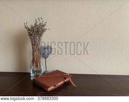 A Glass Vase With Lavender And A Decorative Heart Accentuates The Leather Surface Of The Diary, Crea