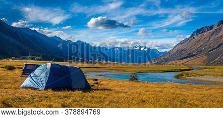 A Tent Pitched Beside The Ahuriri River, Surrounded By Mountains, In Cantebury, South Island, New Ze