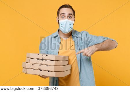 Excited Young Man In Sterile Face Mask Isolated On Yellow Background. Epidemic Pandemic Coronavirus 