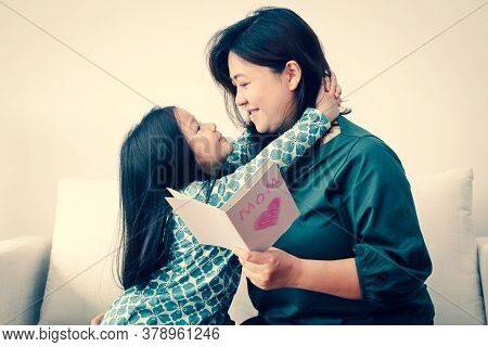 Asian Mother And Child Embracing Each Other The Daughter Wrote A Love Card To Her Mother. Both Are H