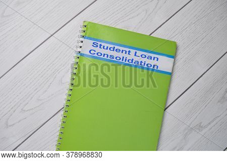 Book About Student Loan Consolidation Isolated On Wooden Table.