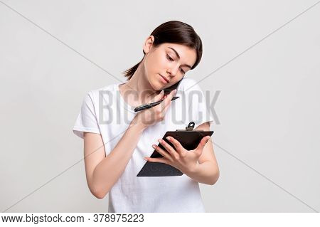 Reservation Service. Call Center. Confident Female Receptionist With Clipboard Discussing Guest List