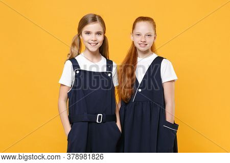 Two Young Little Girls 12-13 Years Old In White T-shirt Blue School Uniform Dresses Isolated On Yell