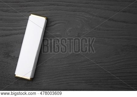 Tasty Chocolate Bar In Package On Grey Wooden Table, Top View. Space For Text