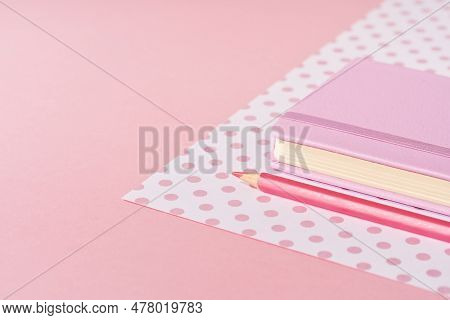 Pink Pencil Tip Touching Desk On Polka Dot Pink Background With Diary Or Copybook. Office Or School 