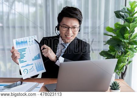 Confident Asian Telesales Businessman Work In Modern Office Wearing Headphone, Presenting Bi Dashboa