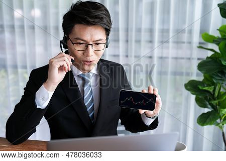 Confident Asian Telesales Businessman Work In Modern Office Wearing Headphone, Presenting Bi Dashboa