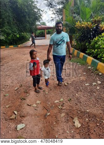Indian Father With Daughter And Toddler Boy Kid Walking And Sitting In A Machohalli Forest Gate.