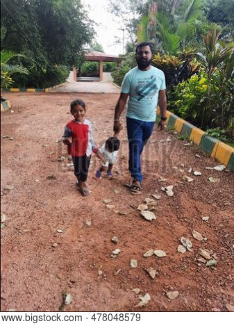 Indian Father With Daughter And Toddler Boy Kid Walking And Sitting In A Machohalli Forest Gate.