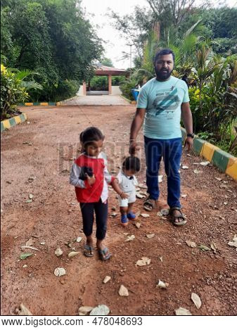 Indian Father With Daughter And Toddler Boy Kid Walking And Sitting In A Machohalli Forest Gate.