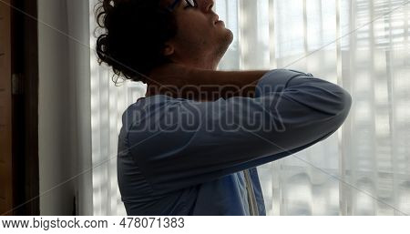 Tired Man Massaging Stiff Neck Tensed Muscles Fatigued From Computer Work