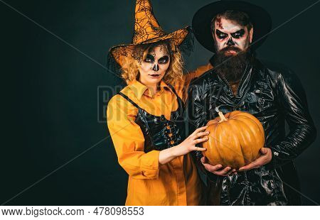 Fashion Glamour Halloween. Young Women Witch In Halloween Hat And Bearded Man Over Black Background.