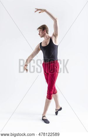 Stretching Of Concentrated Contemporary Ballet Dancer Flexible Athletic Man Posing In Red Tights In