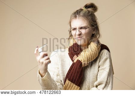 Caucasian Blond Female Girl In Round Glasses Wearing Warm Knitted Sweater Using Throat Spray Against