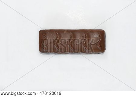 A Chocolate Bar Lies On A White Background