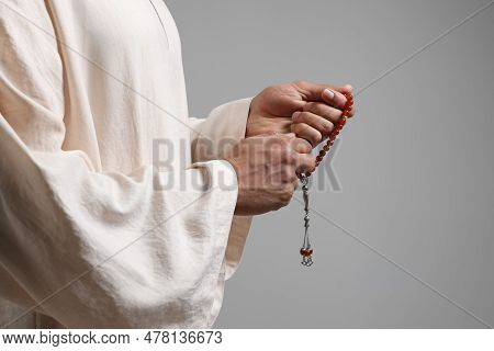 Muslim Woman With Misbaha On Light Grey Background, Closeup