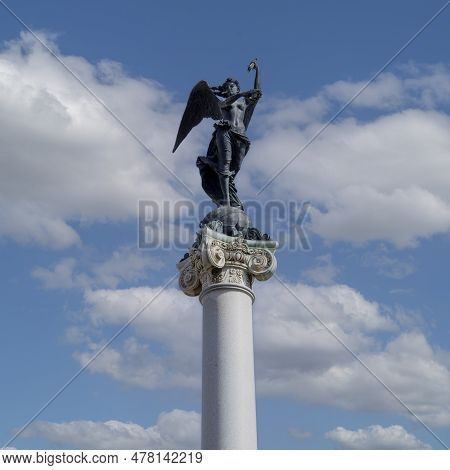 Naples, Italy - June 27, 2021: Bronze Statue Of The Martyrs' Virtue At The Top Of Column Of The Monu