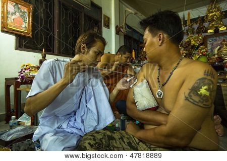 NAKHON CHAI, Tajlandia - MAR 23: Niezidentyfikowane mnich sprawia, że tradycyjne Yantra tatuażu w Wai pełna