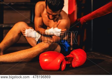 Caucasian Boxer With Pain And Injury After Intense Boxing Training Or Fighting Match, Sitting At The