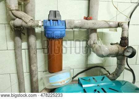 Old Household Filter And Pipes In Water Supply System Of House. Dirty Rusty Filter For Water Purific
