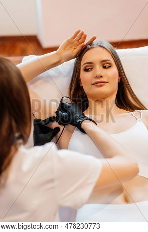 Doctor Is Doing Electroepilation To The Client, Using Electro Needle And Tweezers. Hair Removal Proc