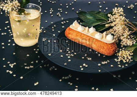French Eclair Grazed With Chocolate Or Sweet Italian Profiteroles With Fresh Cold Dwarf-elder Juice,