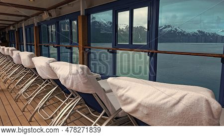 Daybeds In Row. Window View To Coastal Landscape Of Fjords And Glaciers From Resort Daybeds