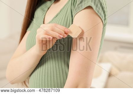 Woman Applying Contraceptive Patch Onto Her Arm Indoors, Closeup