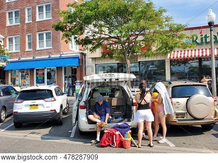 Rehoboth Beach, Delaware, U.s.a - June 18, 2023 - A Family Preparing To Get Into The Beach From The 