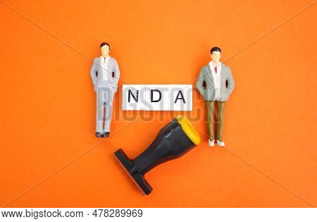 Miniature People With The Letters Nda Or The Word Non-disclosure Agreement. The Concept Of Consent. 