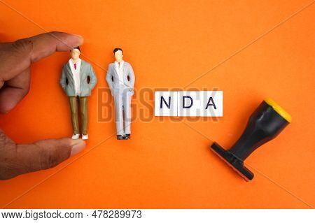 Miniature People With The Letters Nda Or The Word Non-disclosure Agreement. The Concept Of Consent. 