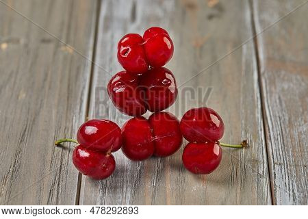 Natures Oddity: Ugly, Irregularly Shaped Cherry Stands Out Against A Rustic Wooden Backdrop