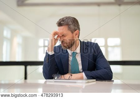 Millennial Businessman In Office Having Headache. Business Man In Suit Work On Laptop At Home Office