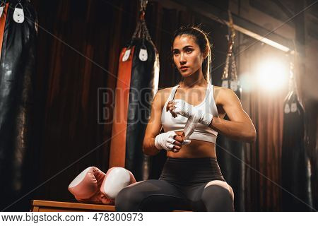 Determined Asian Female Muay Thai Boxer With Muscularity Physical Readiness Body Wraps Her Hand And 