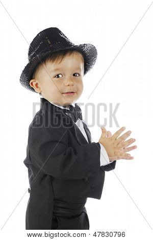 Bir toddler siyah bir smokin ve ışıltılı bir fedora closeup yan görünüm.  Beyaz bir arka plan üzerinde.