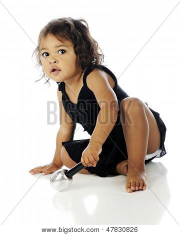 Adorable Toddler sitzen aber bereit in ihrem tanz-Tutu und halten ein Mikro durchführen.  Weiß b