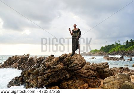 Trans Sexual Black Person Poses On Scenic Ocean Beach Like A Goddess. Lgbtq Ethnic Fashion Model In 