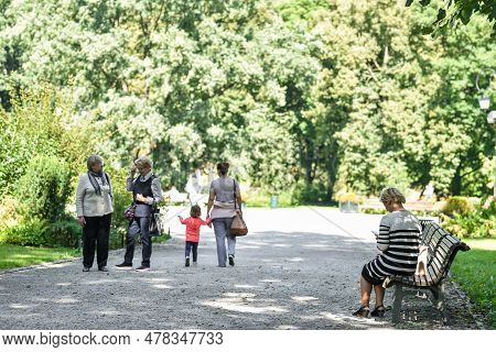 Vilnius, Lithuania - August 31, 2017: Public Park In Lithuania, Vilnius. Old Woman Sitting On The Be