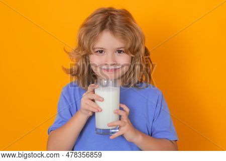 Dairy Milk. Kid Boy With A Glass Of Milk On Studio Background. Cute Child In White Shirt Holding Gla