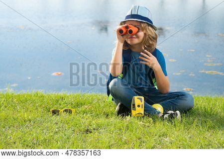 Young Boy Looking Through Binoculars. Explore And Adventure. Child Boy With Backpacks Exploring Natu