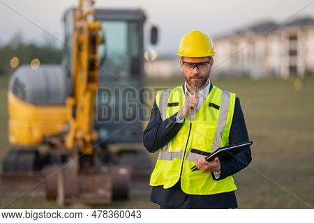 Construction Manager In Suit And Helmet At A Construction Site. Construction Manager Worker Or Super