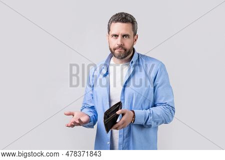 Confused Broke Man With Wallet In Studio. Broke Man With Wallet At Hand. Photo Of Broke Man