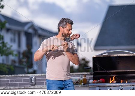 Handsome Man Preparing Barbecue Grill Outdoor. Man Cooking Tasty Food On Barbecue Grill At Backyard.