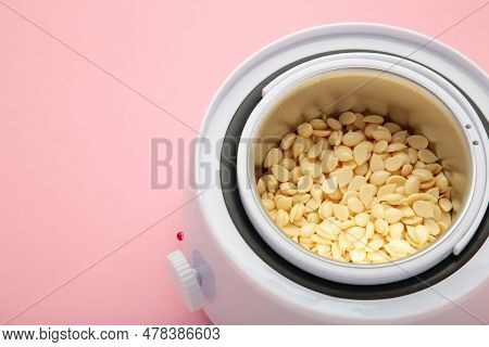 Electric Wax Warmer Or Wax Heater Heater With Wax Drops On Pink Background. Beauty Treatments At Hom