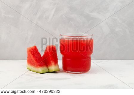 Watermelon Smoothie Or Watermelon Juice In Clear Glass On Grey Background. Near Lie Juicy Slices Wit