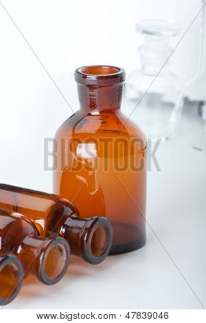 Små kemiske glasflasker på hvid baggrund