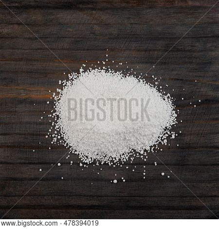 Pile Of Sodium Benzoate, Sodium Salt Of Benzoic Acid On Wooden Surface, Close-up. White Crystalline 