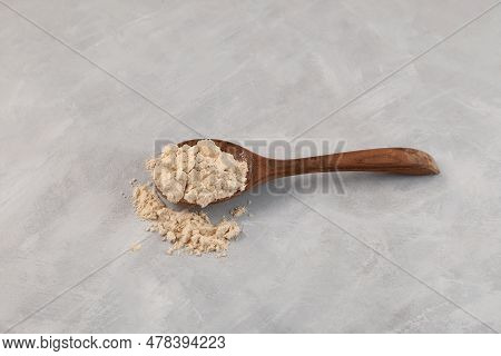 Soy Protein Isolate Or Defatted Soya Flour In Wooden Spoon. Pure Powder Isolated From Soybean Used I