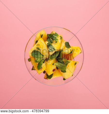 Pineapple Fruit Dessert With Mint In Glass Bowl On Pink Background, Top View. Fresh Pineapple Slices