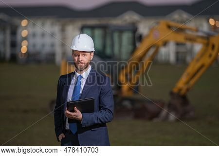 Construction Business Owner. Man In Suit And Hardhat Halmet At Building Construction Site. Civil Eng